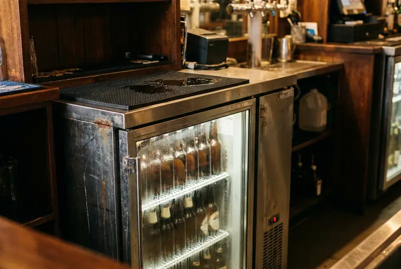 Glass door bottle cooler under a pub bar counter